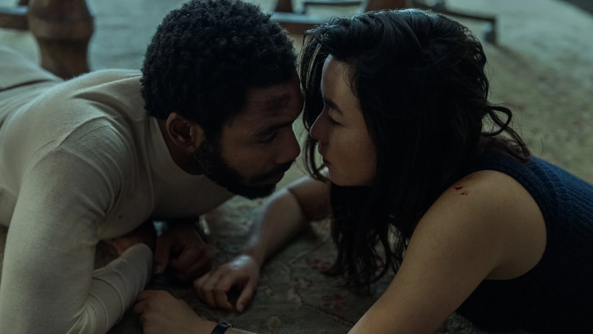 Donald Glover and Maya Erskine are on the floor in 