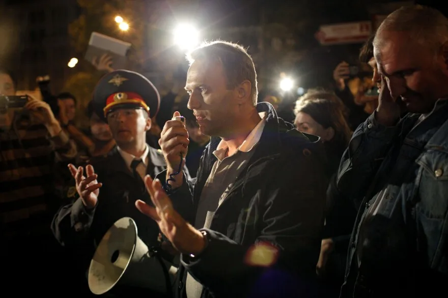 May 8, 2012: Alexei Navalny, a prominent anti-corruption whistle blower and blogger, center, speaks to protesters gathered across the street from the presidential administrations building as a police officer tries to stop him in downtown Moscow.