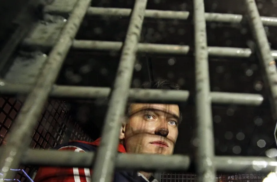 May 8, 2012: Alexei Navalny is seen behind the bars in the police van after he was detained during protests in Moscow, on a day after Putin’s inauguration.