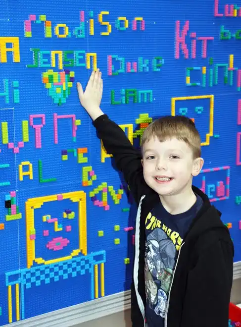 Jensen Finch, 6, of Bondurant adds his name to the graffiti wall at Brick Fest Live featuring life-sized models made from Legos, hands-on activities, and a meet-and-greet with Manny from the 