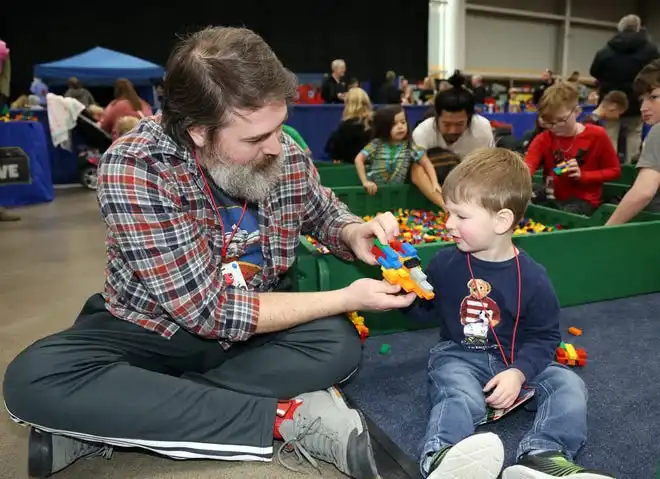 Josh and Miles Heflin, 2, of Ames enjoy family time at Brick Fest Live featuring life-sized models made from Legos, hands-on activities, and a meet-and-greet with Manny from the 