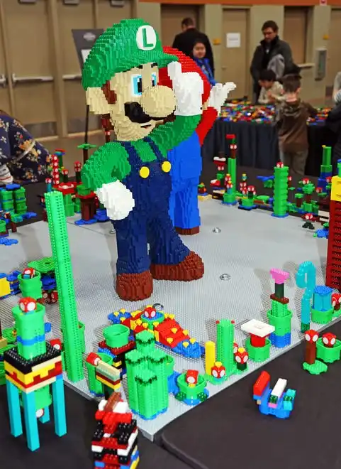 Luigi welcomes guests at Brick Fest Live featuring life-sized models made from Legos, hands-on activities, and a meet-and-greet with Manny from the 