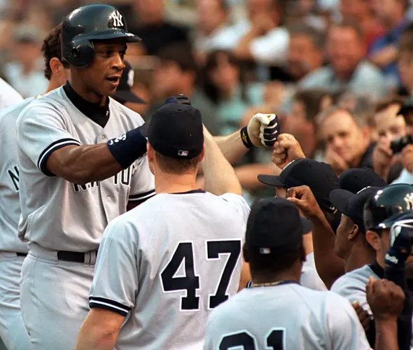 New York Yankees designated hitter Darryl Strawberry, left, receives congratulations as he enters the dugout after hitting a three-run home run against Orioles right-hander Mike Mussina.