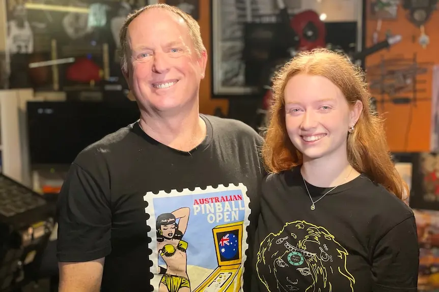 A man and his daughter smile at the camera