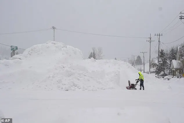 A man uses a snow blower as snow piles up during a storm, Sunday, March 3, 2024, in Truckee