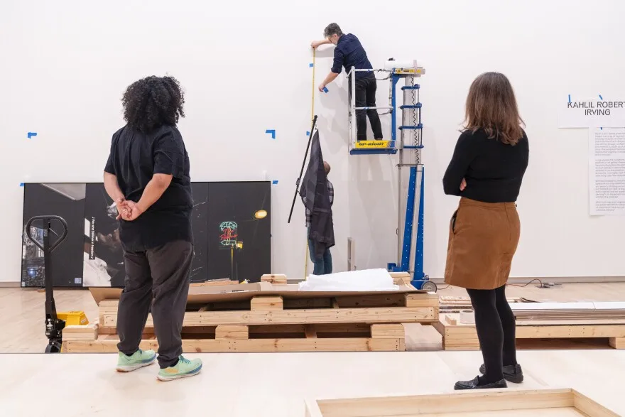 Kahlil Robert Irving and Meredith Malone, curator at the museum, watch as a piece is placed during installation of Irving’s upcoming exhibition “Archaeology of the Present” on Friday, Feb. 16, 2024 at the Mildred Lane Kemper Art Museum at Washington University in St. Louis. The exhibition will open to on February 23 and run through July 29.