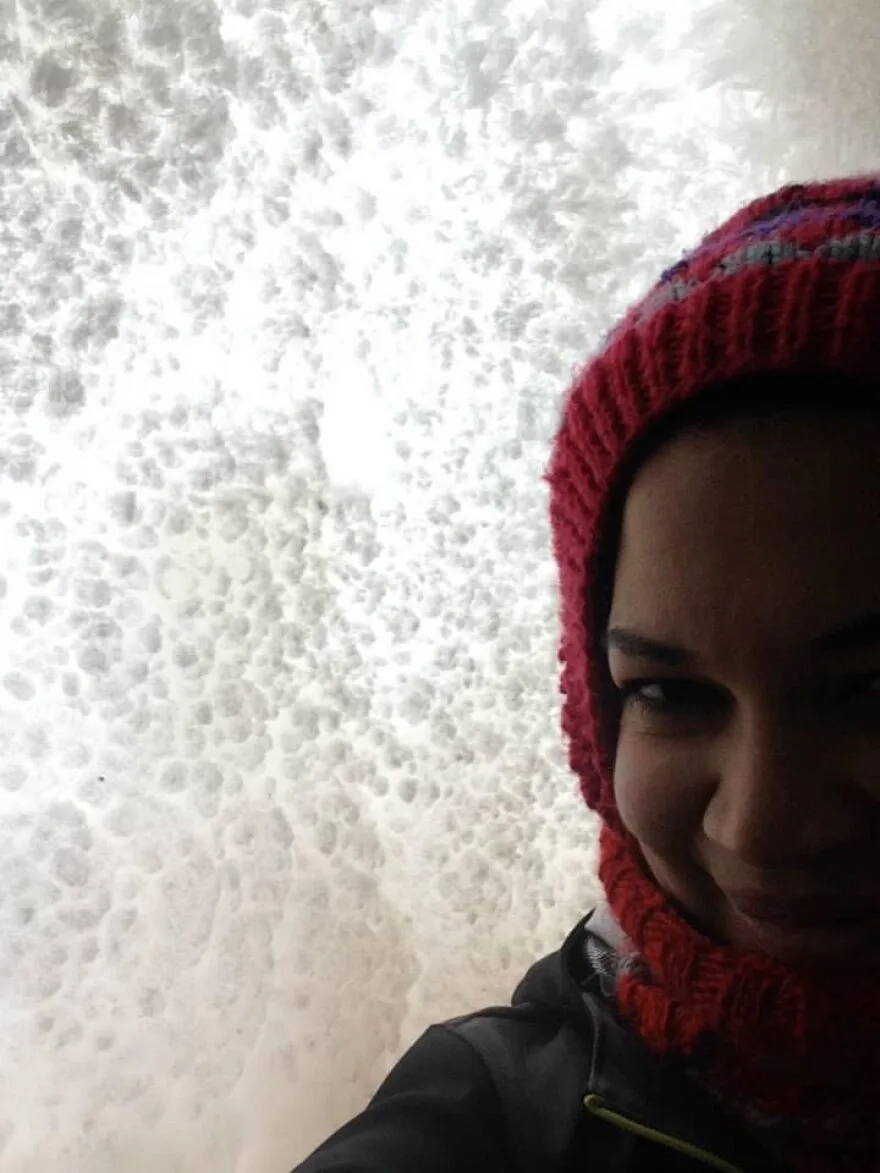 a portrait of a light-skinned black woman in a knit headband outside on a winter day