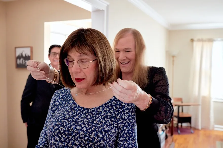 Nicole Brownstein adds a necklace to Bernie’s Wagenblast’s outfit.