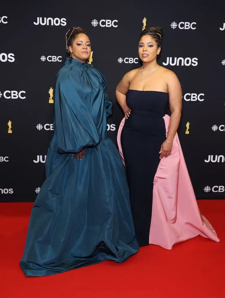 Magdelys Savigne and Elizabeth Rodriguez of Okan on the Juno Awards red carpet wearing floor-length gowns.