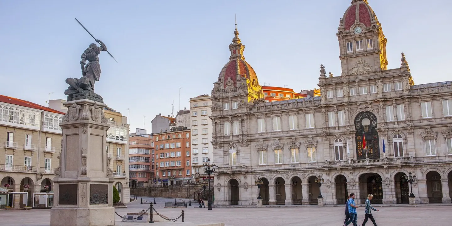 Three people walking through a European plaza at sunset