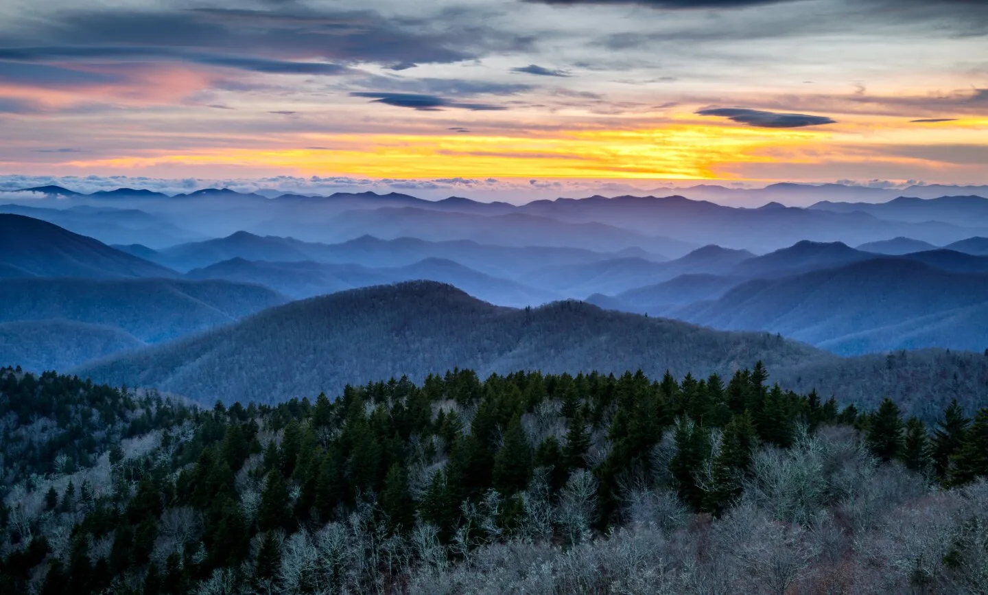 A colorful sunset over the Blue Ridge Mountains shrouded in a wintery haze.