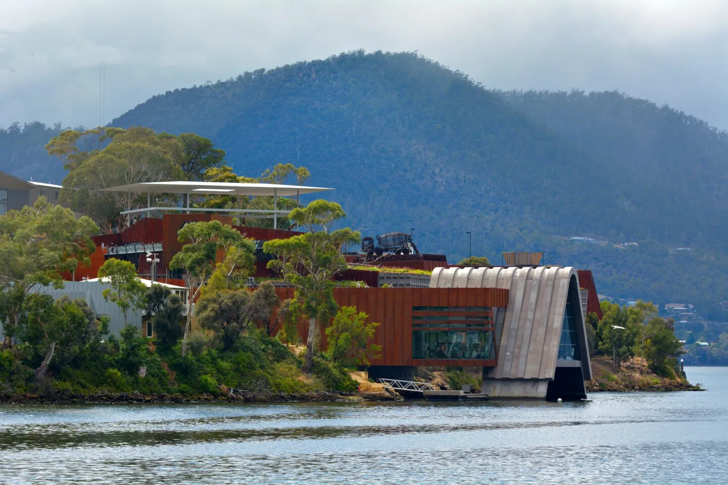 Red, futuristic building jutting out into water