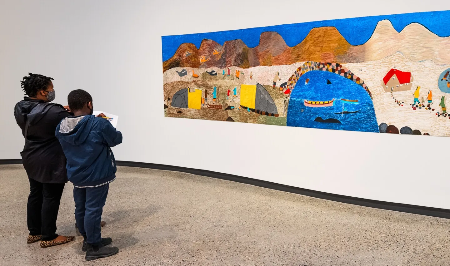 Two people looking at a colorful piece of art in a gallery