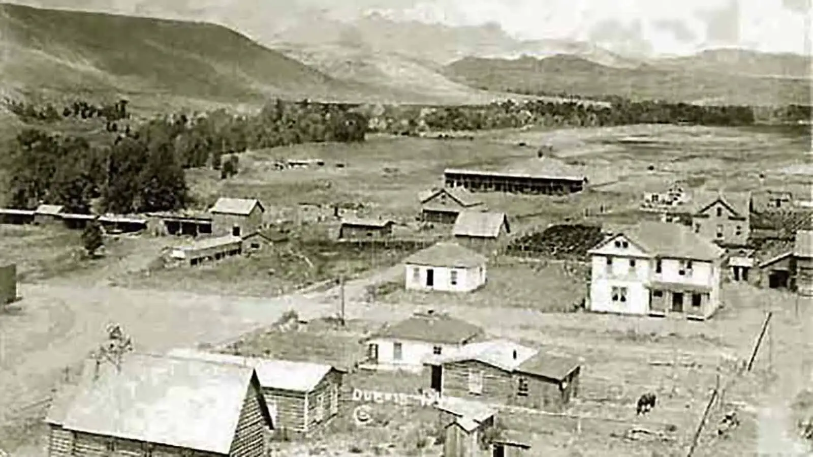 The Stringer Hotel, right, in 1915 about a year after it was built in Dubois, Wyoming. Today, it’s had several expansions to take up the whole city block, including where that house is to the left.