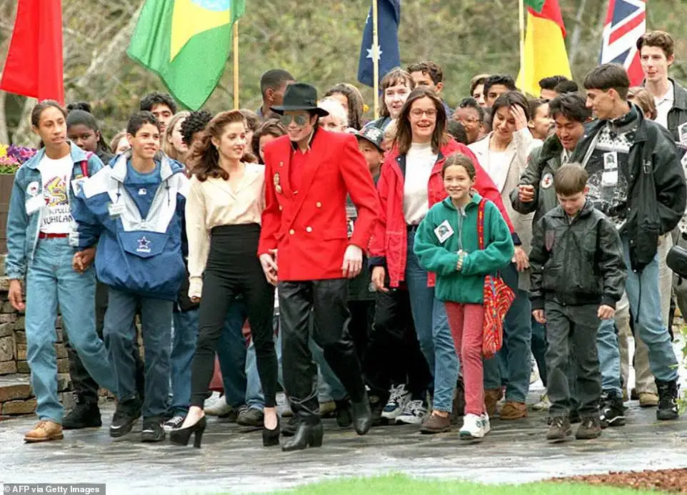 Michael Jackson is seen holding hands with his former wife Lisa Marie Presley as they walk with children at his Neverland Ranch, welcoming them for a three day World Summit of Children in 1995