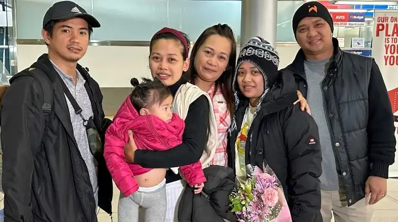 A family stands for a photo at the airport.