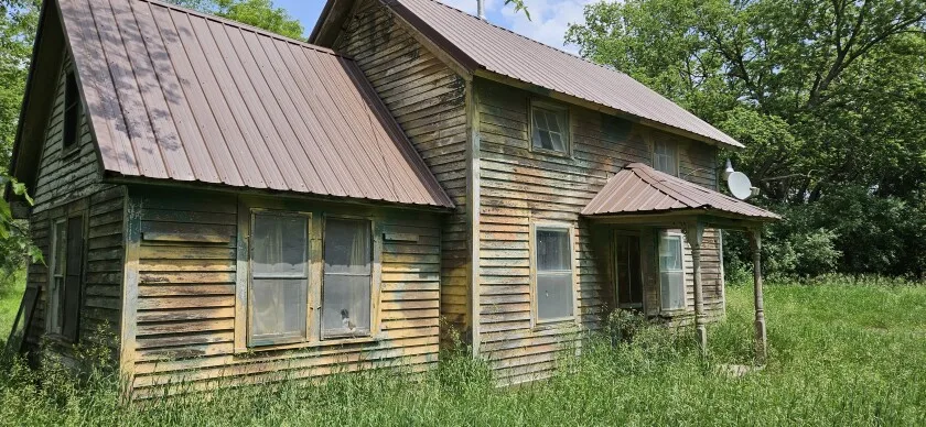 The Iverson Log Cabin, right, more or less remained hidden for decades. The exterior and interior siding covered the cabin logs for decades. The cabin had been used for many years as a hunting shack. Undated photo shows the cabin and attached building in Tunsburg Township west of Watson in Chippewa County.