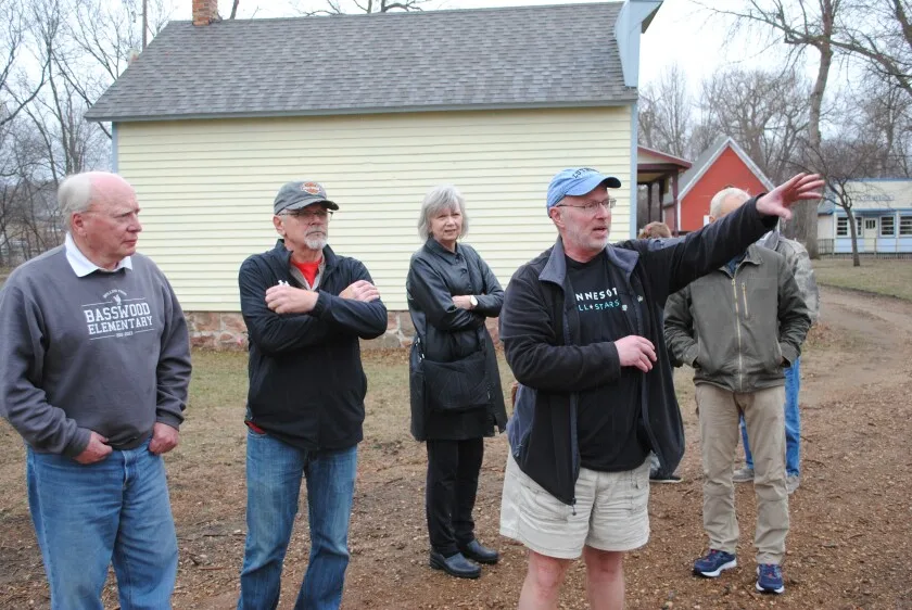 Paul Ostlie, with arm raised, led members of the Chippewa County Historical Society board of directors and Endowment Board on a tour of the site in the Hiistoric Chippewa Village where it is hoped the cabin and attached building can be located. They viewed the site on April 8, 2024.