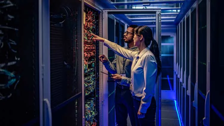 IT engineers checking servers in server room