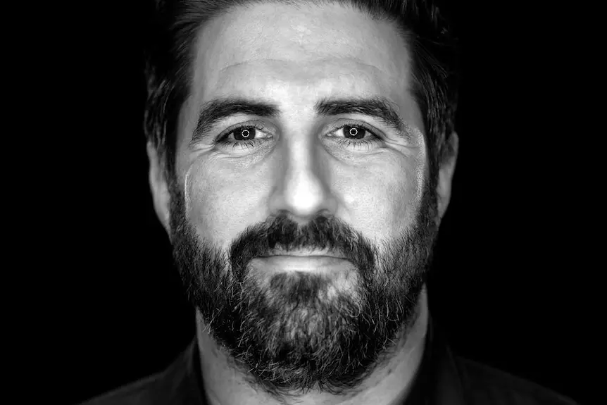 A black and white photo of a man with a beard.