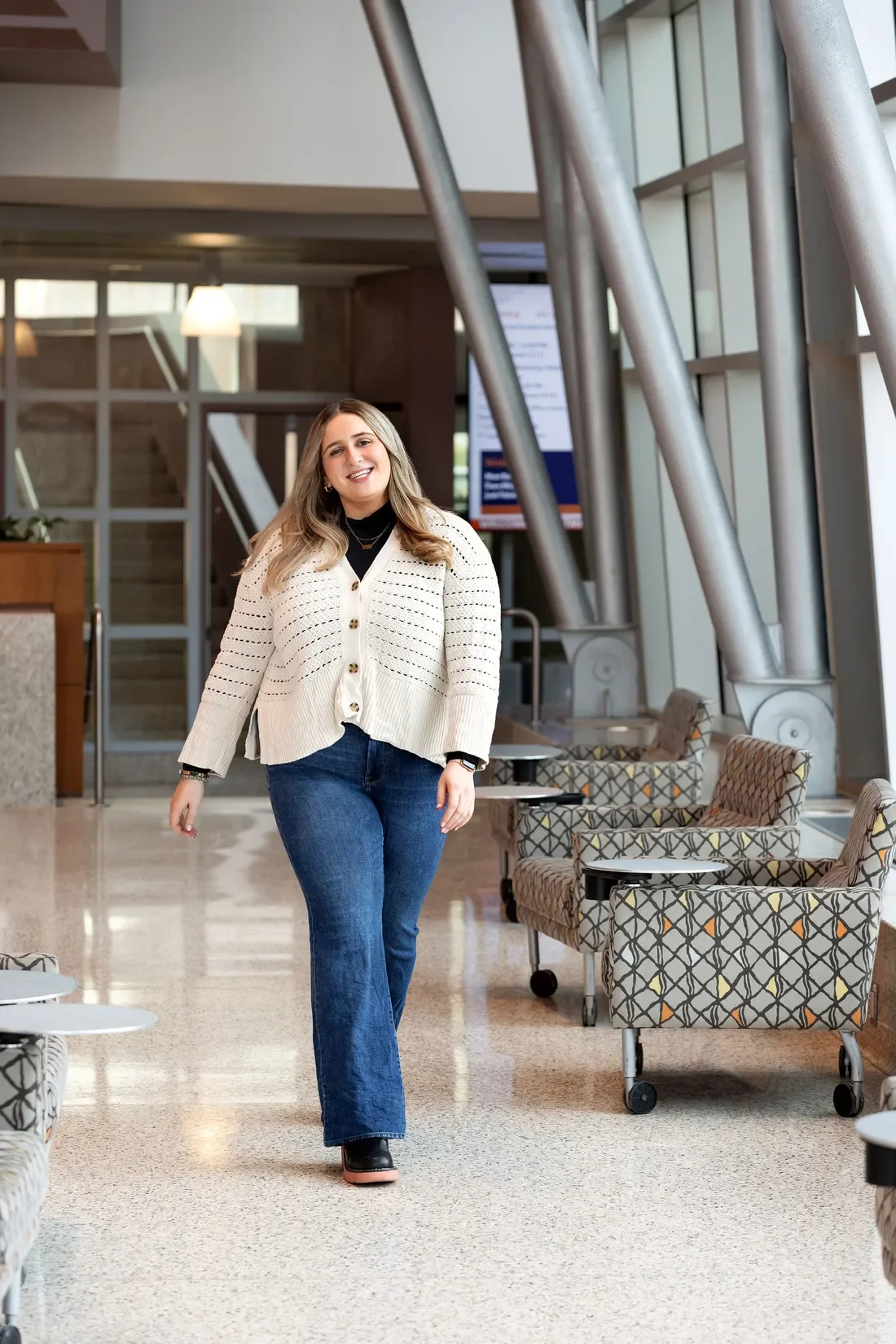 Isabella Simon walking in a building on syracuse University’s campus.