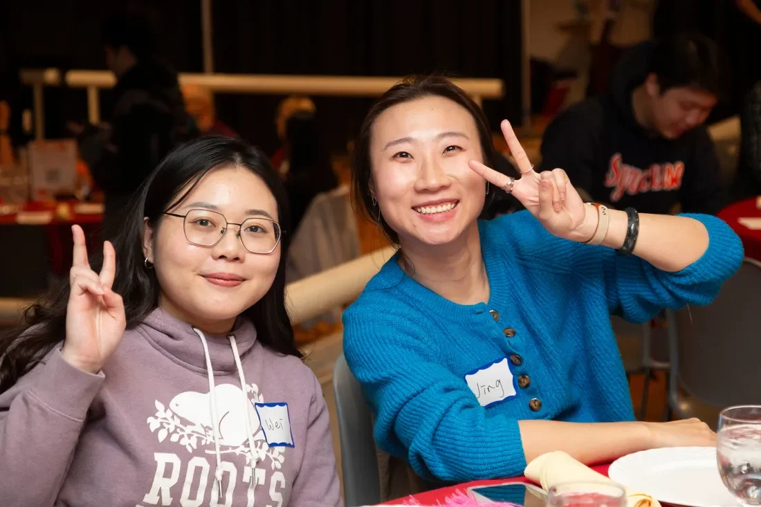 Two people putting up peace signs.