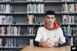 Max Decker, a senior at Lincoln High School, sits for a portrait in the school library where he often worked on writing his college essays, in Portland, Ore., Wednesday, March 20, 2024. (AP Photo/Amanda Loman)