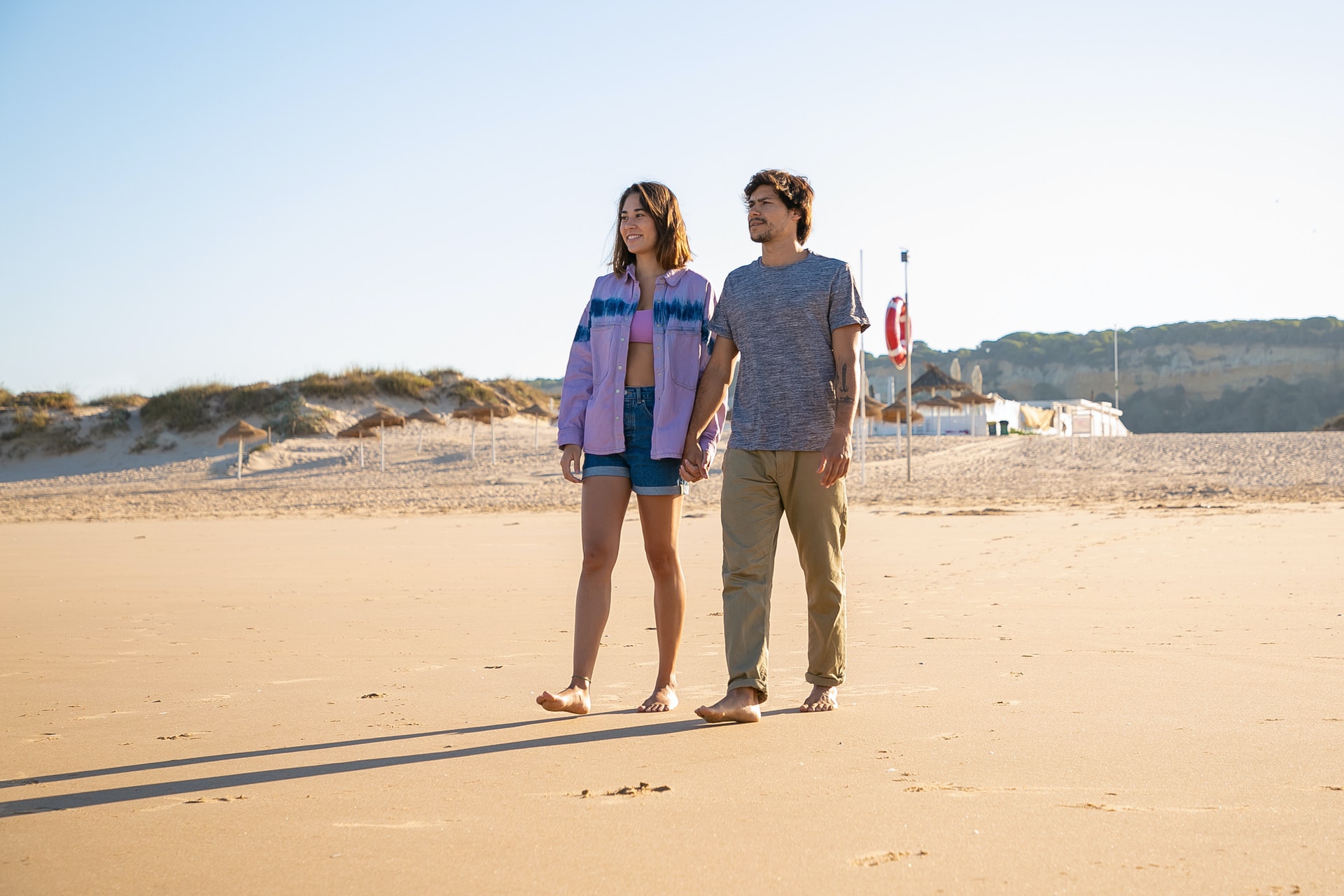 couple walking barefoot on sand