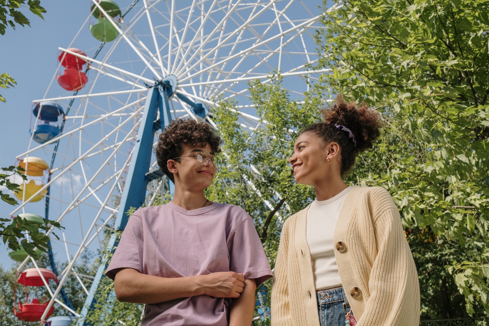 teenagers standing under ferris wheel