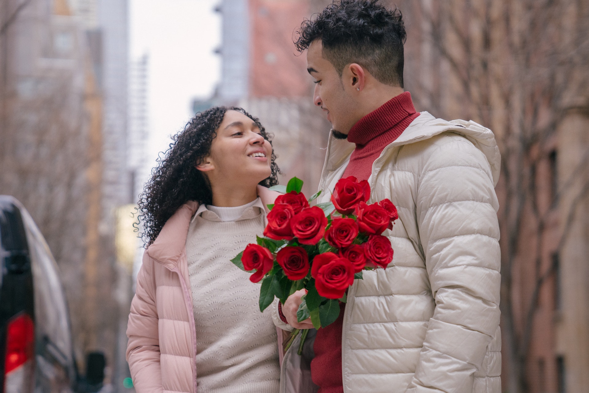 a couple with bunch of red roses