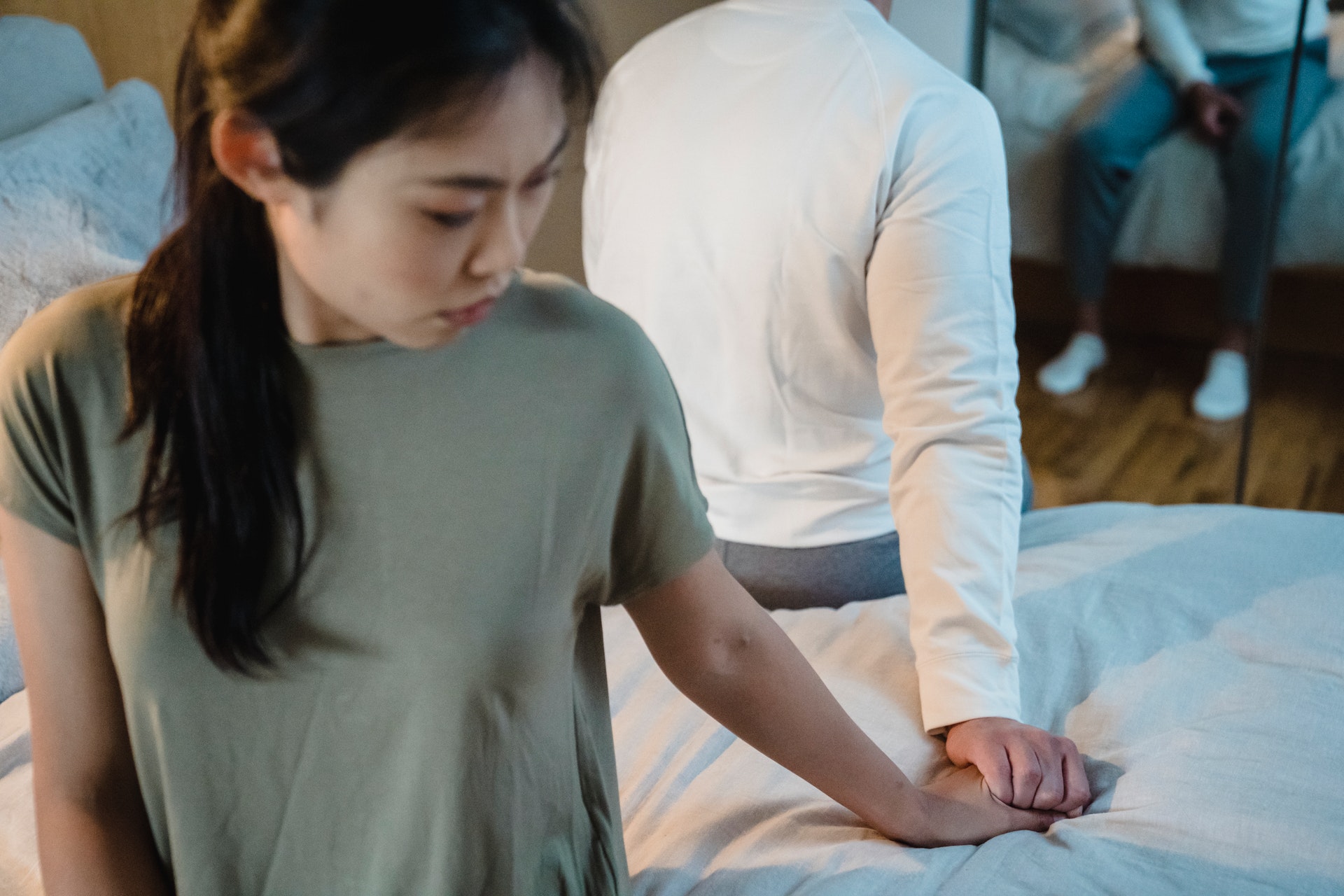 couple holding hands while sitting back to back