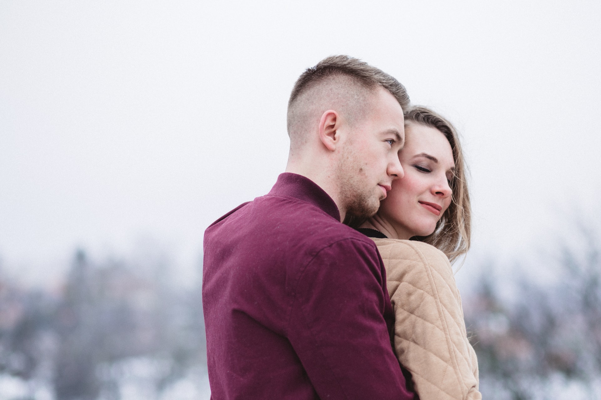 man hugging woman while standing