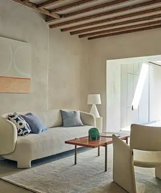 Neutral room with textures walls and cream curved couch