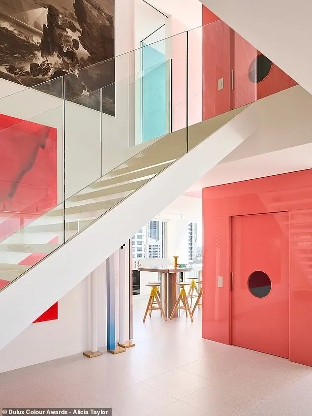 SJB Interiors' Gold Coast Apartment did both, adding ruby red chairs in a sunshine yellow dining room and coating the entryway walls with a unique shade of vermilion