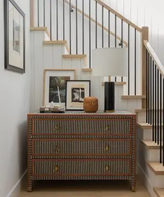 staircase with chest of drawers