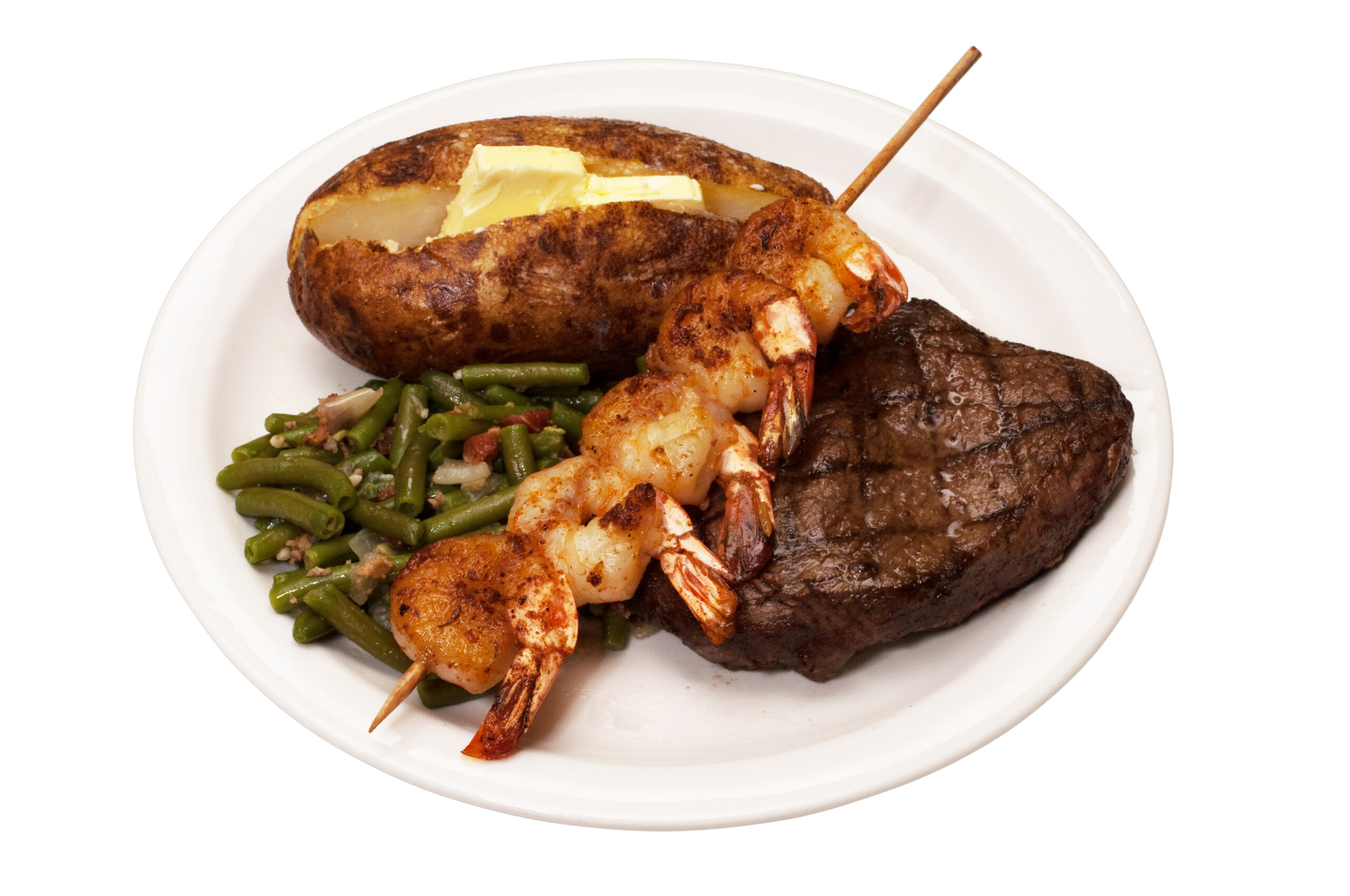 Sirloin steak with baked potato, green beans and shrimp on skewer isolated on white background with clipping path.