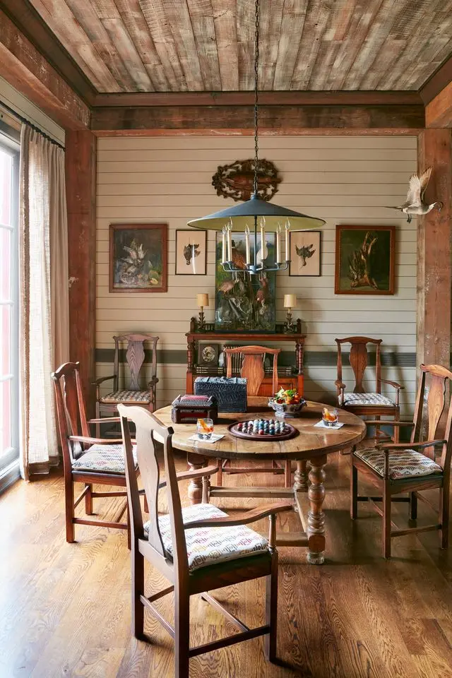 revelry in the pines richard keith langham's rural mississippi hunting lodge a 19th century french oak table and oak armchairs invite guests to pull a seat up to game night embroidered chair fabric, kravet dining room