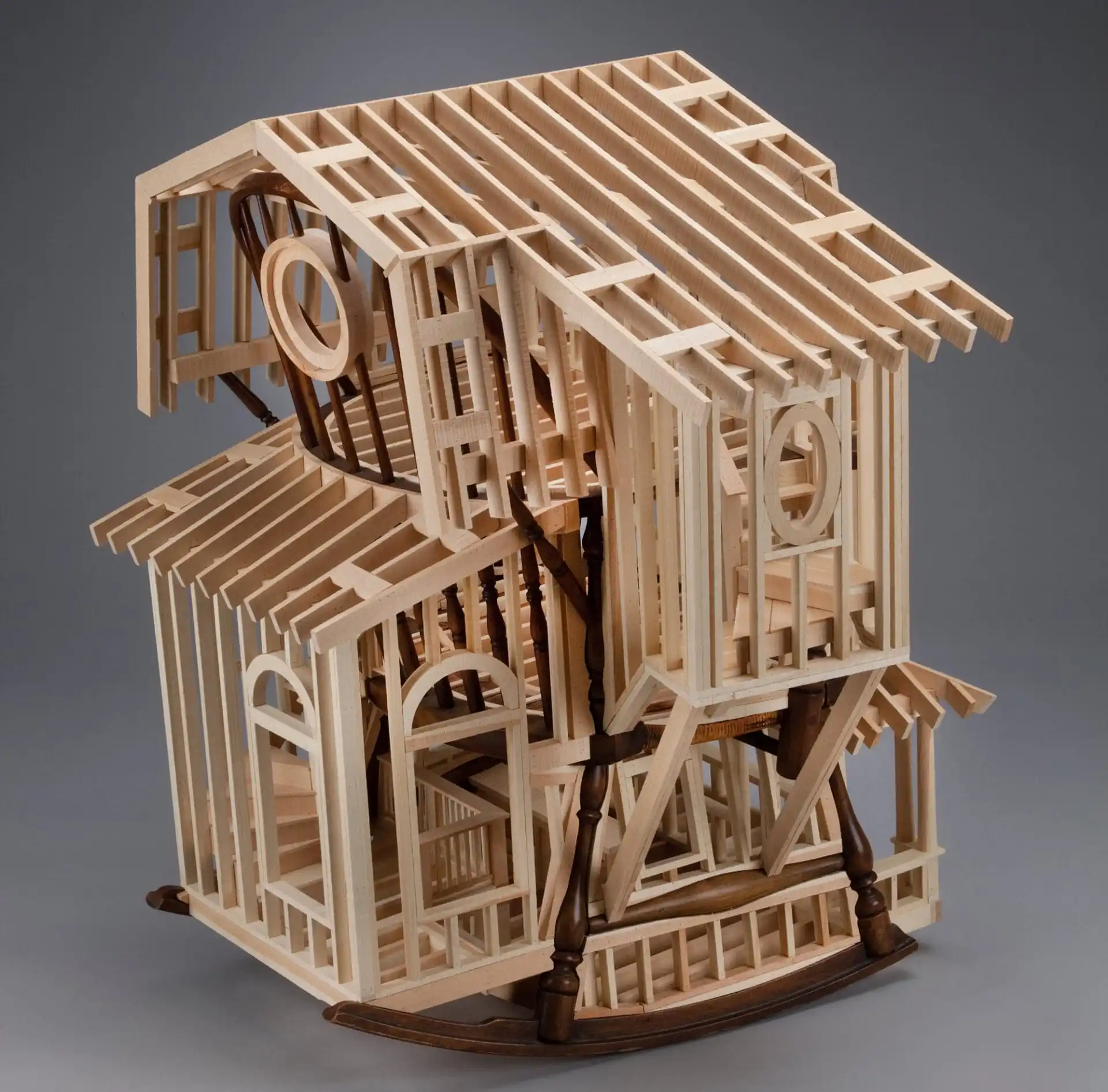 a wooden house frame is built around a child's rocking chair