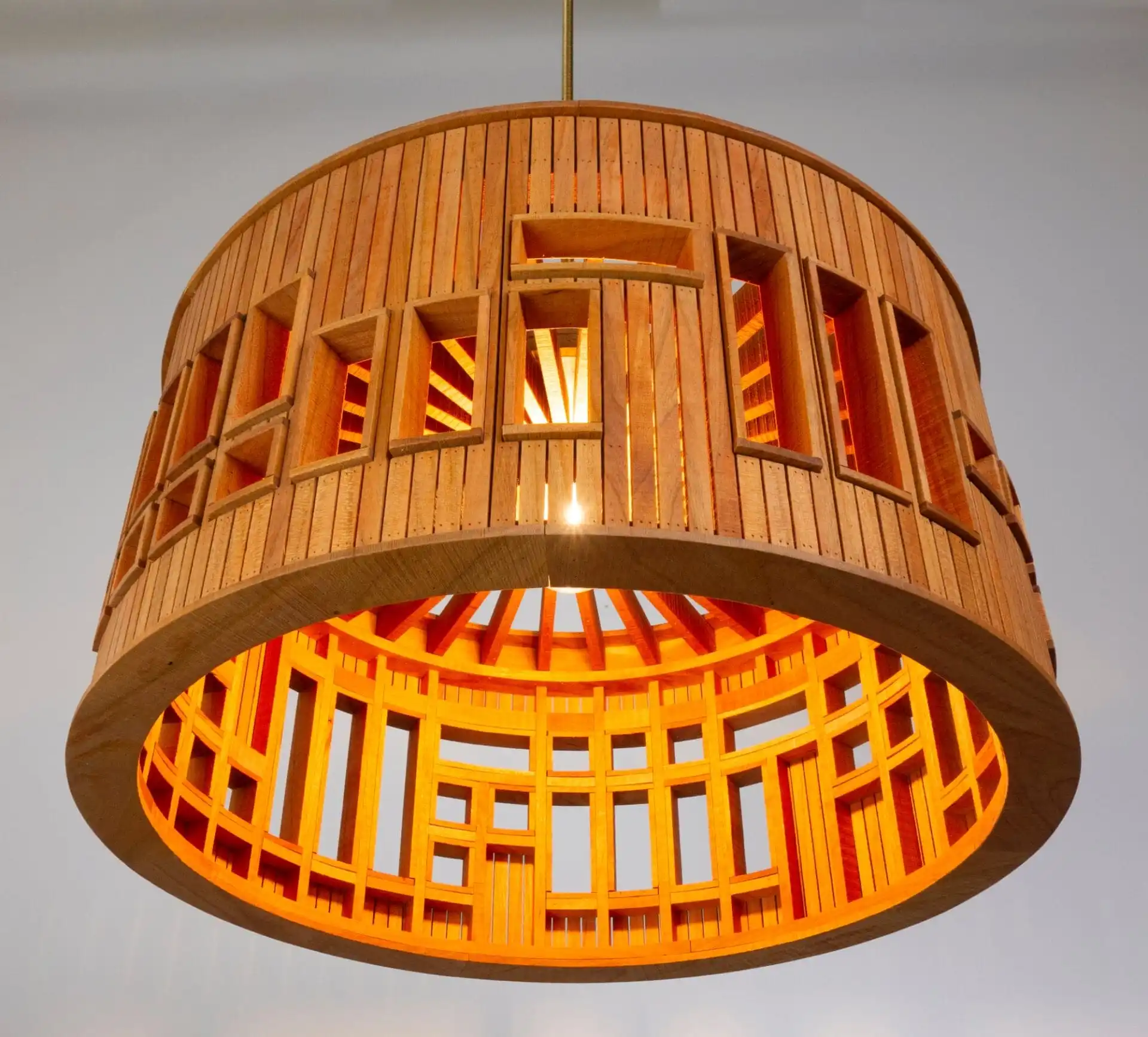 a wooden suspended barrel shade with windows built into the side to appear like a hosue