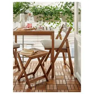 a wooden table, chair and stool on a balcony with hanging planters