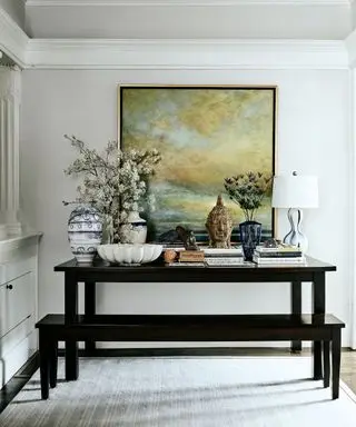 dark wood bench and table with landscape painting behind