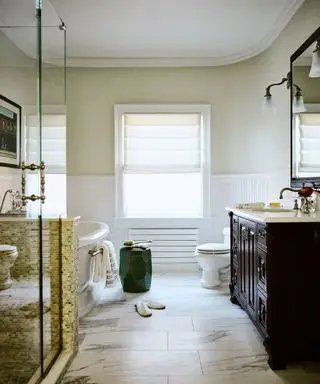 bathroom with dark wood vanity and roll-top bath