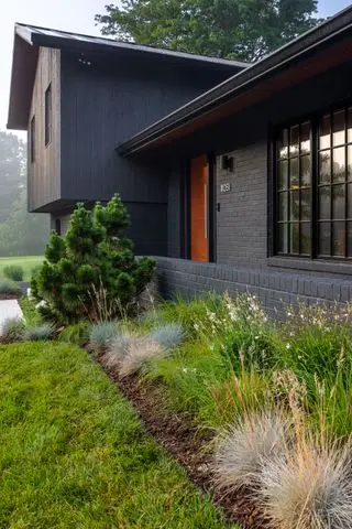 a front yard with natural flower bed planting