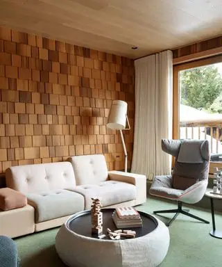 living room with wooden tiles on walls and white sofa with picture window