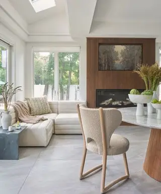 family room breakfast nook with cream sofa and wood framed fireplace