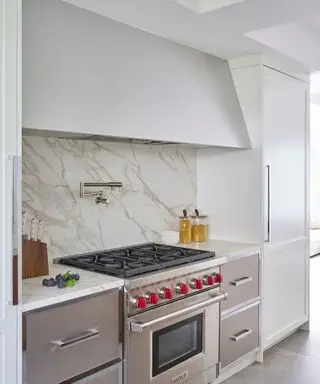 kitchen with marble backsplash and large cooker hood