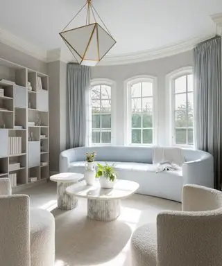 living room with pale curved sofa and bay window