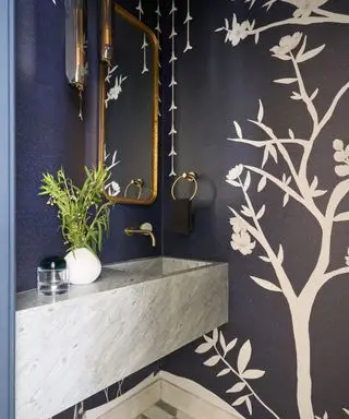 powder room with dark walls and tree motif and marble vanity