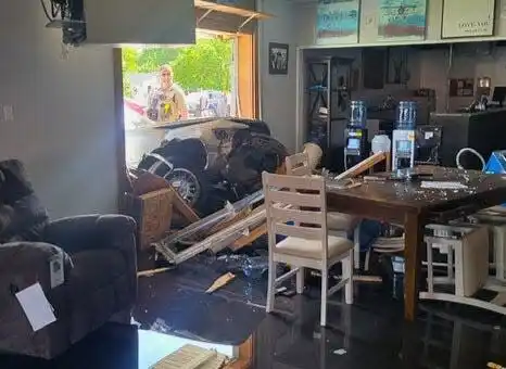 The front end of a Mercury brand automobile is seen Monday, May 17, 2024, after crashing into Curly’s Furniture Store in Streator. Three people were seriously injured in the crash which took place after a police pursuit.