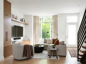 The rounded shapes of the living room furnishings soften the more rigid lines of the window and door casings and the rectilinear media centre.